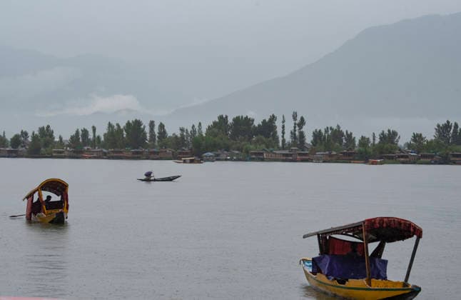 July 20, 2026, Srinagar, Jammu And Kashmir, India: Boatmen row their Shikara boats during heavy rainfall in Srinagar.Torrential rain unleashed flash floods and landslides in Pir Panjal region of J&Ks Poonch and Rajouri districts Sunday, killing at least 14 people, leaving several missing and burying homes under walls of water, rock and mud that barrelled down mountain slopes. Officials said the toll could rise as rescuers searched for those trapped beneath debris. Srinagar India - ZUMAz120 20260720_zip_z120_014 Copyright: xBasitxZargarx