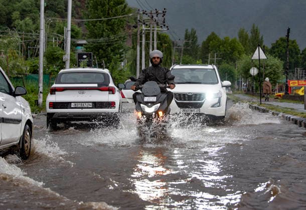 July 20, 2026, Srinagar, Jammu And Kashmir, India: People travel with their vehicles through a waterlogged road during heavy rainfall in Srinagar.Torrential rain unleashed flash floods and landslides in Pir Panjal region of J&Ks Poonch and Rajouri districts Sunday, killing at least 14 people, leaving several missing and burying homes under walls of water, rock and mud that barrelled down mountain slopes. Officials said the toll could rise as rescuers searched for those trapped beneath debris. Srinagar India - ZUMAz120 20260720_zip_z120_016 Copyright: xBasitxZargarx