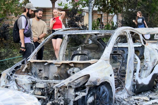 People look at a burnt-out car in the Shevchenkivskyi district after a large-scale overnight Russian missile attack, Kyiv, Ukraine, July 19, 2026. The Russian army launched a massive attack on the capital with ballistic missiles. According to the State Emergency Service of Ukraine, an 89-year-old woman was killed and 15 people were injured. Falling debris and fires were reported in five districts of the city, while a direct hit was recorded at the underpass near Lukianivska metro station. (Photo by Pavlo Bahmut Ukrinform) Russian missile hits underground passage near Lukianivska metro station in Kyiv  Copyright: xPavloxBahmutx