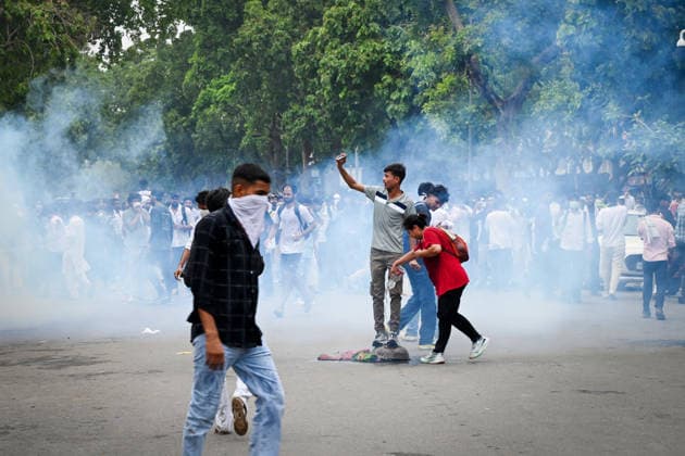 NEW DELHI, INDIA - JULY 20: A CJP protestor clicking a selfie atop inverted iron pan used to stop tear gas hurled by Delhi Police to disperse supporters of the Cockroach Janta Party (CJP) after they gather in large numbers and breach security barricades on DR Rajendra Prasad Road near Parliament House on July 20, 2026 in New Delhi, India. The protesters were demanding the resignation of Union Education Minister Dharmendra Pradhan over alleged examination irregularities. (Photo by Ajay Aggarwal Hindustan Times) Delhi Police Use Lathi Charge And Tear Gas Shells To Disperse CJP Supporters During Their March To Parliament
