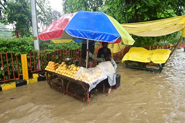 July 20, 2026, Prayagraj, Uttar Pradesh, India: Prayagraj: A Roadside vendor sit at a waterlogged road after heavy rain, in Prayagraj on Monday, July 20, 2026. Prayagraj India - ZUMAv115 20260720_zap_v115_037 Copyright: xPrabhatxKumarxVermax