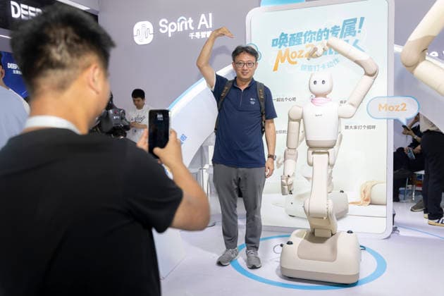 (260720) -- SHANGHAI, July 20, 2026 -- A visitor and a humanoid robot make heart gestures as they pose for photos during the 2026 World AI Conference and High-Level Meeting on Global AI Governance in Shanghai, east China, July 20, 2026. The 2026 World AI Conference and High-Level Meeting on Global AI Governance concluded here on Monday. ) CHINA-SHANGHAI-WORLD AI CONFERENCE-CONCLUSION (CN) WangxXiang 