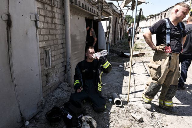 A firefighter drinks water at a garage cooperative hit by a Russian guided aerial bomb strike in the Voznesenivskyi district of Zaporizhzhia, Ukraine, July 20, 2026. The attack destroyed or damaged privately owned garages, while the blast wave and debris wrecked civilian cars. A woman was killed at the site of the strike, and five others were injured. (Photo by Dmytro Smolienko Ukrinform) Russian strike garage co-op in central Zaporizhzhia with guided bomb  Copyright: xDmytroxSmolienkox