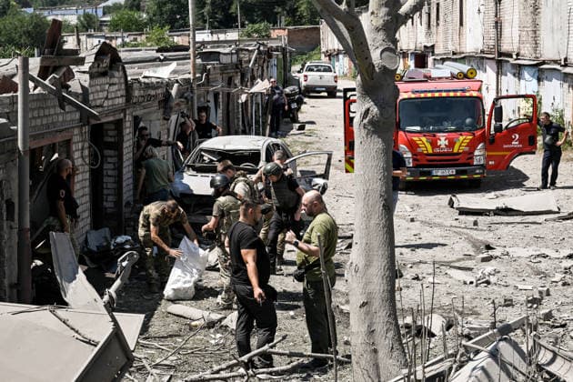 Law enforcement officers, forensic experts and military personnel record damage at a garage cooperative caused by a Russian guided aerial bomb strike in the Voznesenivskyi district of Zaporizhzhia, Ukraine, July 20, 2026. The attack destroyed or damaged privately owned garages, while the blast wave and debris wrecked civilian cars. A woman was killed at the site of the strike, and five others were injured. (Photo by Dmytro Smolienko Ukrinform) Russian strike garage co-op in central Zaporizhzhia with guided bomb  Copyright: xDmytroxSmolienkox