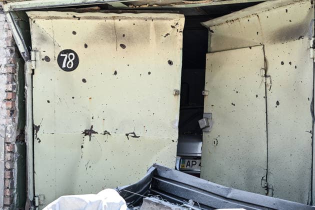 Metal gates are damaged by debris and a shock wave from a Russian guided aerial bomb strike on a garage cooperative in the Voznesenivskyi district of Zaporizhzhia, Ukraine, July 20, 2026. The attack destroyed or damaged privately owned garages, while the blast wave and debris wrecked civilian cars. A woman was killed at the site of the strike, and five others were injured. (Photo by Dmytro Smolienko Ukrinform) Russian strike garage co-op in central Zaporizhzhia with guided bomb  Copyright: xDmytroxSmolienkox