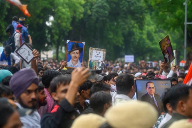 July 20, 2026, New Delhi, New Delhi, India: NEW DELHI, India Ã¢â‚¬ Protesters hold up portraits of Bhagat Singh and B.R. Ambedkar along with a copy of India s Constitution at Jantar Mantar during demonstrations by the Cockroach Janata Party (CJP) demanding the resignation of Education Minister Dharmendra Pradhan over alleged irregularities in the NEET-UG exam, July 20, 2026. New Delhi India  - ZUMAm184 20260720_zip_m184_031 Copyright: xAnkitxRoyxMajumderx