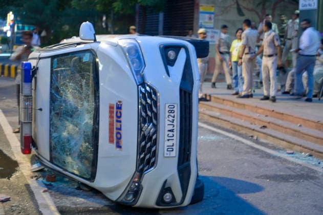 NEW DELHI, INDIA - JULY 20: A view of a police vehicle damaged during clashes involving CJP protesters on Janpath on July 20, 2026 in New Delhi, India. Protesters marching toward Parliament defied prohibitory orders under Section 163, leading to severe altercations with police. The clash resulted in nearly 50 police personnel injured and over 70 detentions. Delhi Police buses and SUVs were smashed. The march was organized to demand accountability for exam paper irregularities and the resignation of Education Minister Dharmendra Pradhan.(Photo by Raj K Raj Hindustan Times) Delhi Police Vehicles Damaged Following CJP Protest March