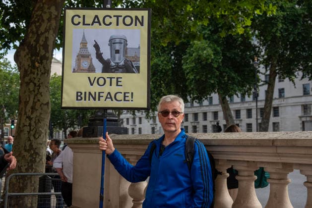July 20, 2026, London, England, United Kingdom: A lots of people gathered outside Downing Street to support and protest against the new Prime Minister of the United Kingdom, Andy Burnham..A protester holds a sign with a photo from Count Binface who is a candidate on the Clacton by-election in the UK. London United Kingdom  - ZUMAe120 20260720_zip_e120_007 Copyright: xKrisztianxElekx