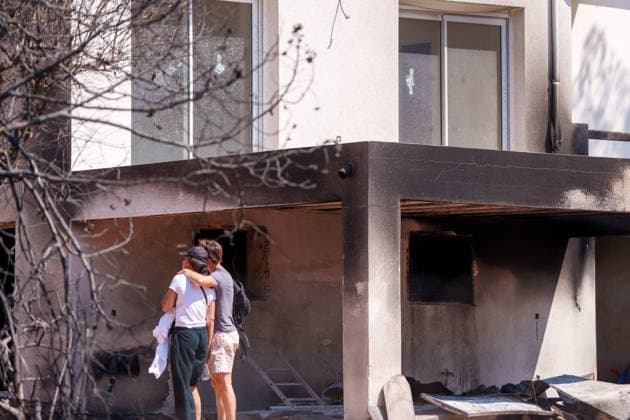 South France suffers from wildfires after another heatwave. France - Les Arcs, 20.07.2026 A burned house side with man holding a women in his arm as wildfires burning near Les Arcs-sur-Argens in southeastern France on Monday. The blaze was one of several wildfires affecting the country during a period of extreme heat, longer lasting drought and strong winds, led to evacuations and a large-scale firefighting response. DÃ partement Var