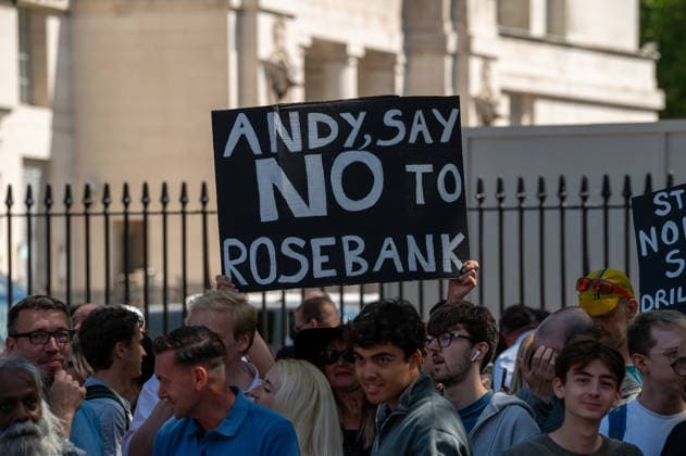 July 20, 2026, London, Westminster, United Kingdom: An activist holds a placard expressing his opinion during a protest prior to the swearing-in of Prime Minister Andy Burnham outside Downing Street. Fossil Free London activists protest outside Downing Street as Andy Burnham is sworn in as Prime Minister, urging him to reject the Rosebank oil field and new North Sea drilling. Protesters held placards highlighting heat deaths and UK wildfires alongside a banner reading Stop Rosebank . The action follows reports that the new government could approve Rosebank within days and is the latest in a series of high-profile protests against new fossil fuel extraction. London United Kingdom  - ZUMAs197 20260720_aaa_s197_283 Copyright: xJamesxWilloughbyx
