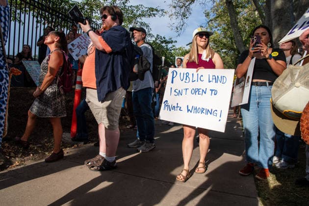 July 20, 2026, Salt Lake City, Utah, USA: A protester holds a sign reading Public Land Isn t Open to Private Whoring! outside the Utah Governor s Mansion in Salt Lake City, Utah, on Monday, July 20, 2026. The community rally was organized to protest executive actions drastically reducing the boundaries of the Bears Ears and Grand Staircase-Escalante national monuments. Salt Lake City USA  - ZUMAm292 20260720_znp_m292_012 Copyright: xCharlesxMcClintockxWilsonx