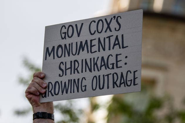July 20, 2026, Salt Lake City, Utah, USA: A protester holds a sign reading GOV COX S MONUMENTAL SHRINKAGE: GROWING OUTRAGE outside the Utah Governor s Mansion in Salt Lake City, Utah, on Monday, July 20, 2026. The community rally was organized to protest executive actions drastically reducing the boundaries of the Bears Ears and Grand Staircase-Escalante national monuments. Salt Lake City USA  - ZUMAm292 20260720_znp_m292_025 Copyright: xCharlesxMcClintockxWilsonx
