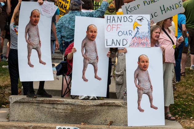 July 20, 2026, Salt Lake City, Utah, USA: Protesters hold signs depicting the face of U.S. Senator Mike Lee on small bodies alongside a Hands Off Our Land sign outside the Utah Governor s Mansion in Salt Lake City, Utah, on Monday, July 20, 2026. The community rally was organized to protest executive actions drastically reducing the boundaries of the Bears Ears and Grand Staircase-Escalante national monuments. Salt Lake City USA  - ZUMAm292 20260720_znp_m292_047 Copyright: xCharlesxMcClintockxWilsonx