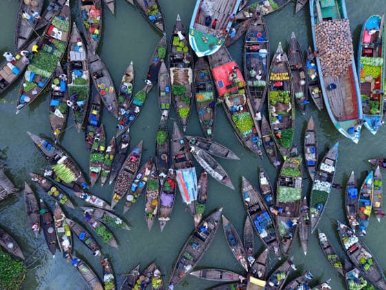 July 21, 2026, Baithakata, Pirojpur, Bangladesh: Buyers and sellers gather with their small wooden boats at the nearly 200 year old Baithakata Floating Market in Nazirpur Union, Pirojpur district, Bangladesh. Trading takes place entirely from wooden boats along a narrow canal, while local farmers from surrounding villages arrive by water carrying fresh vegetables, fruits, rice, paddy, seedlings, spices and other daily essentials to one of the region™s largest traditional floating markets. Baithakata Bangladesh - ZUMAk174 20260721_zip_k174_002 Copyright: xSyedxMahabubulxKaderx