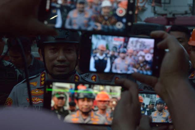 Police Investigate Fatal House Explosion - Medan Medan Police Chief Sr. Comr. Jean Calvijn Simanjuntak, center, wearing a police helmet, speaks to media and joint SAR teams at the site of a fatal house explosion in a luxury residential area of Medan, North Sumatra, on July 21, 2026. He stated that while initial investigators found evidence of gas, the full investigation is ongoing to determine if any other substances were present at the scene. The SAR team, along with forensic laboratory units, PLN, and PGN, used heavy machinery to clear debris, successfully recovering the last of three victims buried in the rubble on Tuesday afternoon. Joint search and recovery operations involving all teams, including Basarnas personnel (right), are wrapp  Copyright: xAdityaxSutanta ABACAx