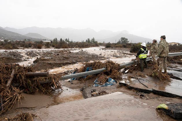 (260721) -- SANTIAGO, July 21, 2026 -- Rescue workers inspect a damaged part of a highway in Coquimbo region, Chile, July 19, 2026. Heavy rains have battered Chile s northern Atacama and Coquimbo regions since last week. The rainfall has killed at least ten people, prompting the declaration of a state of emergency. CHILE-COQUIMBO-FLOODS ZhuxYubo 