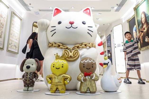CHINA, HONG KONG - JULY 21, 2026: A giant figurine of Maneki-neko and Christmas season installations at the Landmark shopping malls Hong Kong China  - ZUMAt113 20260721_zaa_t113_263 Copyright: xMikhailxSinitsynx