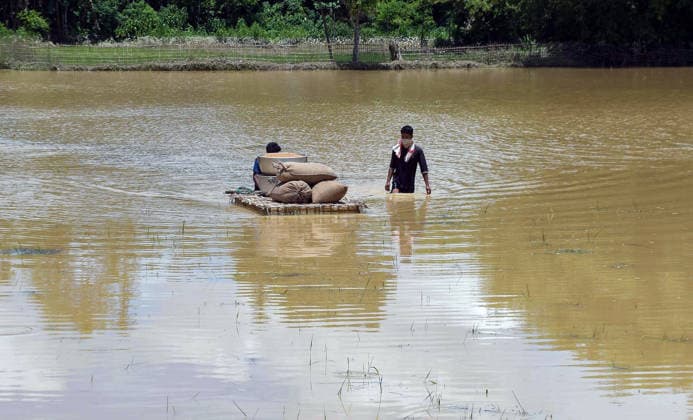 A man carrying edible items wades through flood water at Teok Jorhat, Jul 21 (ANI): A man carrying edible items wades through flood water at Teok, in Jorhat on Tuesday. Jorhat Assam India Copyright: xANIx ANI_20260721487