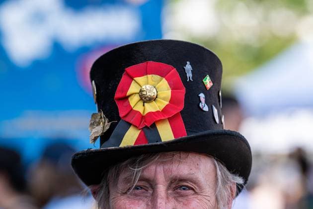 A person wears a hat with a Belgian flag on it at the Everyone to the Table initiative by Resto National at Vossenplein - Place du Jeu de Balle, as part of the National Holiday, on Tuesday 21 July 2026 in Brussels.  JONASxROOSENS 181694902