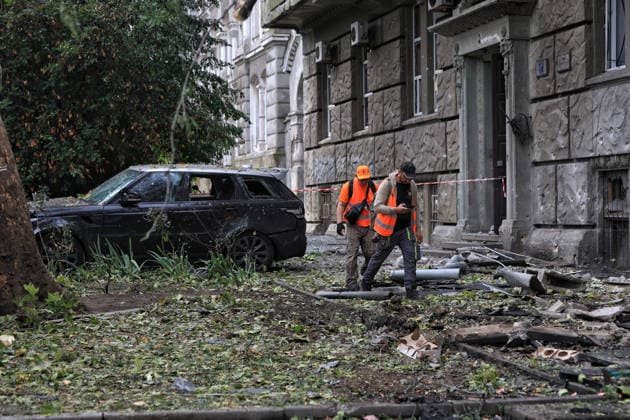 Municipal workers walk through debris in the street after a Russian combined strike, Odesa, Ukraine, July 21, 2026. The Russian army carried out a missile and drone attack on the southern Ukrainian port city and the region. The attack damaged the residential building, nearby structures and cars. Three people were injured. (Photo by Nina Liashonok Ukrinform) Russians attack historical centre in Odesa  Copyright: xNinaxLiashonokx