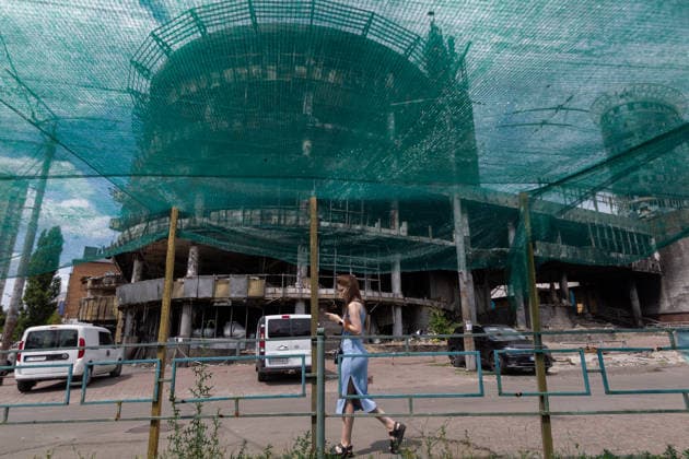 A woman walks past the Kvadrat shopping centre destroyed in the large-scale Russian attack on the night of May 23–24, 2026, Kyiv, Ukraine, July 21, 2026. On Sunday night, July 19, 2026, Russia launched a massive missile strike on the Ukrainian capital. The Lukianivka historical neighbourhood was hit again. The strike damaged the Lukianivska metro station, its vestibule and foyer, and wrecked the Lukianivka market. The underground passage on Yuriia Illienka Street was also directly struck. (Photo by Kyrylo Chubotin Ukrinform) Lukianivka neighbourhood in Kyiv recovers from massive Russian attack  Copyright: xKyryloxChubotinx