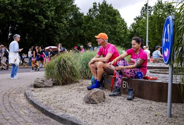 WIJCHEN - Two participants take a short rest on a roundabout on the second day of the Nijmegen Four Days Marches. On the Wednesday of the Four Days Marches, Nijmegen positions itself as the pink rainbow capital of the Netherlands. ROBIN VAN LONKHUIJSEN ANP netherlands out - belgium out  Copyright: xx x564044277x originalFilename: 564044277.jpg