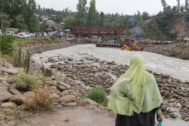 July 22, 2026, Budgam, Jammu And Kashmir, India: A woman stands near the Sukhnag River close to the site of a shopping complex damaged by flash floods following heavy rain in Beerwah. The severe weather leaves at least 22 people dead in the Poonch and Rajouri districts. Budgam India - ZUMAa205 20260722_zip_a205_008 Copyright: xAdilxAbassx