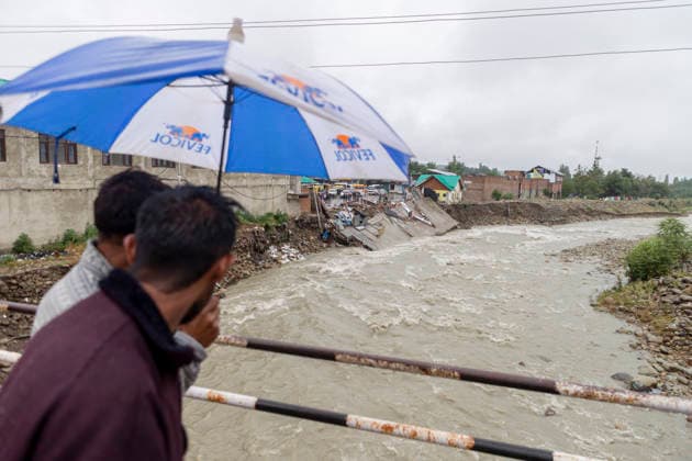 July 22, 2026, Budgam, Jammu And Kashmir, India: People walk with umbrellas as they inspect the damage after a shopping complex is damaged by flash floods following heavy rain in Beerwah. The severe weather leaves at least 22 people dead in the Poonch and Rajouri districts, forces the closure of educational institutions until July 26, and leads to the suspension of the Amarnath Yatra. Budgam India - ZUMAa205 20260722_zip_a205_013 Copyright: xAdilxAbassx