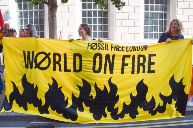 July 22, 2026, London, United Kingdom: Protesters hold a World on fire banner during a protest outside the Department for Energy Security and Net Zero (DESNZ) organised by the group Fossil Free London, calling on the new Energy Secretary Miatta Fahnbulleh and the new UK Prime Minister Andy Burnham to stop the Rosebank oil and gas field in the North Sea. London United Kingdom  - ZUMAs197 20260722_aaa_s197_034 Copyright: xVukxValcicx
