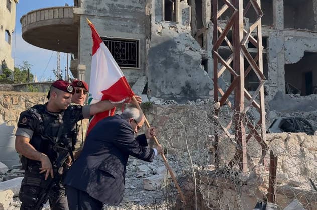 Lebanese Prime Minister Nawaf Salam places a national flag along a damaged street in the southern village of Zawtar al‘Gharbiya on Wednesday, July 22, 2026, following the withdrawal of Israeli troops from the area. During his visit, Salam said Beirut is working toward a complete Israeli withdrawal from occupied territories. The Lebanese army has recently deployed in the village as part of efforts to reassert state authority.  LEB2026072201 LebanesexPrimexMinister sxMedia
