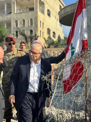 Lebanese Prime Minister Nawaf Salam places a national flag along a damaged street in the southern village of Zawtar al‘Gharbiya on Wednesday, July 22, 2026, following the withdrawal of Israeli troops from the area. During his visit, Salam said Beirut is working toward a complete Israeli withdrawal from occupied territories. The Lebanese army has recently deployed in the village as part of efforts to reassert state authority.  LEB2026072202 LebanesexPrimexMinister sxMedia