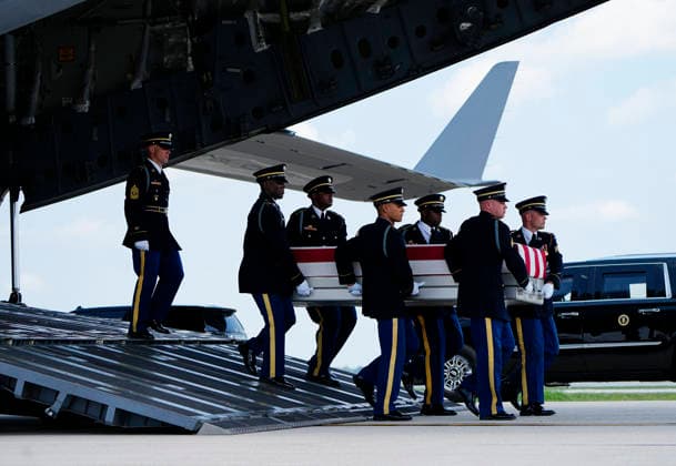 President Donald Trump watches as a U.S. Army carry team carries the transfer case containing the remains of Army Staff Sgt. Emmanuel Swinton during a dignified transfer at Dover Air Force Base in Dover, Delaware on Wednesday, July 22, 2026. Swinton, who was killed during a controlled detonation of an Iranian drone in Iraq, will receive a Bronze Star, Purple Heart, Combat Action Badge, and was posthumously promoted to staff sergeant.  DEL202607222006 BONNIExCASH