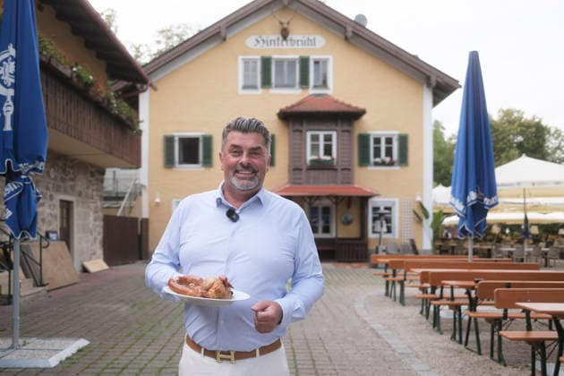 Marcus Wagner (Wirt) mit 1 2 Hendl - Neueröffnung der Isarbar im Biergarten Hinterbrühl, München 22.07.2026 *** Marcus Wagner, bar owner with 1 2 Hendl; Grand reopening of the Isarbar in the Hinterbrühl beer garden, Munich, July 22, 2026