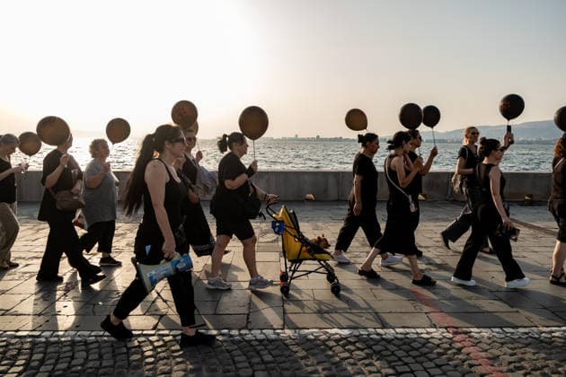 July 22, 2026, Izmir, Turkey: Animal rights activists seen walking on streets while holding black balloons with animal footsteps during their silent march. Animal rights advocates held a silent march in Izmir, Turkey, to call for the protection of stray animals and their right to life. Following the march, participants issued a statement urging humane and permanent solutions for stray animals while calling on the public to defend the right to life and adopt animals from shelters or the streets. Izmir Turkey - ZUMAs197 20260722_aaa_s197_501 Copyright: xMuratxKocabasx