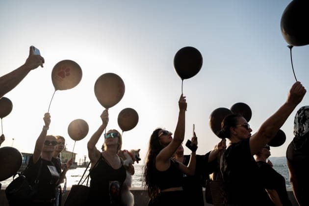 July 22, 2026, Izmir, Turkey: Animal rights activists seen standing on the street while holding black balloons with animal footsteps during their silent march. Animal rights advocates held a silent march in Izmir, Turkey, to call for the protection of stray animals and their right to life. Following the march, participants issued a statement urging humane and permanent solutions for stray animals while calling on the public to defend the right to life and adopt animals from shelters or the streets. Izmir Turkey - ZUMAs197 20260722_aaa_s197_513 Copyright: xMuratxKocabasx