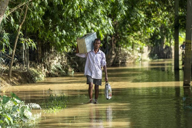 Flood in Indian Northeastern State Assam JORHAT, INDIA - JULY 22: A resident wades through floodwaters while carrying a metal trunk and essential belongings from his inundated home in a flood-affected neighborhood, on July 22, 2026 in Jorhat, India. The flood situation in Assam remained critical, with more than 630,000 people affected across 21 districts. The state’s death toll has risen to 12. David Talukdar Anadolu Jorhat India. Editorial use only. Please get in touch for any other usage.  Copyright: x2026xAnadoluxDavidxTalukdarx