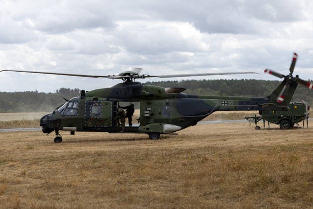 Bundesminister Boris Pistorius besucht Transporthubschrauberregiment 30, Külsheim,23.07.2026 Ein NH90-Transporthubschrauber der Bundeswehr steht mit laufenden Rotoren auf einem Übungsgelände, während Soldaten am geöffneten Laderaum arbeiten. Rechts ist militärisches Bodenstützgerät zu sehen. Das Transporthubschrauberregiment 30 Tauberfranken demonstrierte im Rahmen der NATO-Vorbereitung einen Konturenflug. Hardheim Baden-Württemberg Deutschland *** Federal Minister Boris Pistorius visits Transport Helicopter Regiment 30, Külsheim, July 23, 2026. A Bundeswehr NH90 transport helicopter stands with its rotors spinning on a training ground, while soldiers work on the open cargo compartment. Military ground support equipment can be s 20260723-1V9A5685-M4000
