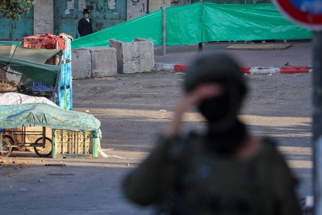 Hebron Market Closed for Tomb Visit An Israeli soldier stands near a market street screened off with green fabric in Hebron, Palestine, on July 23, 2026. Israeli forces closed the central market and restricted the movement of Palestinians in the city of Hebron during a raid on the area to secure settlers access to an ancient tomb, where they performed Jewish prayers. Hebron West Bank Palestinian Territories Copyright: xMosabxShawerx