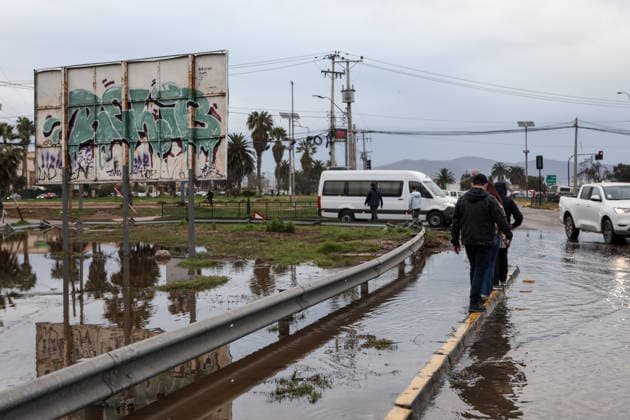 July 23, 2026, La Serena, Chile: People make their way along a flooded street following a storm that affected various regions of the country, causing widespread flooding and power outages. A state of catastrophe was declared for La Serena, Chile. La Serena Chile - ZUMAu105 20260723_zip_u105_014 Copyright: xManuelxUrzuax