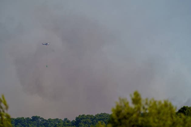 Wildfire reignites with strong Mistral wind in France. France - Cotignac, 23.07.2026 A Helicopter in the clouds of smoke as a wildfire spreads again near Cotignac in the Var department, southeastern France on Thursday. Strong Mistral winds fueled renewed fire activity, prompting a large firefighting operation. Departement Var