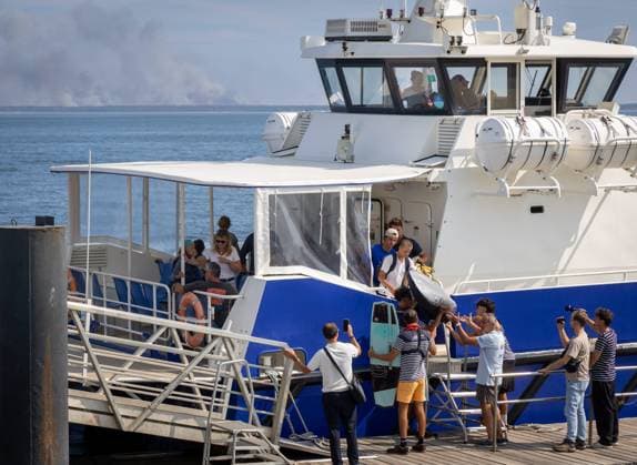 Fire: Evacuees arrive in Arcachon from the Lége-Cap Ferret Peninsula. PHOTOPQR SUD OUEST. Laurent Theillet. Arcachon, July 24, 2026. Fire, evacuees arrive in Arcachon from the Lége-Cap Ferret peninsula Arcachon, July 24, 2026 Arcachon, France, July 24, 2026 Fire at Cap Ferret—boat evacuations underway. Ferry services have been set up at four piers, and all residents and vacationers have been asked to evacuate as the flames advance. Arcachon, GIRONDE, France  Copyright: xPHOTOPQR SUDxOUEST MAXPPPxLaurentxTheilletx 20260724SDO8020 20260724SDO8031