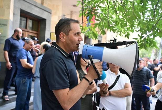 Armenia Opposition Leader Arrest 9211103 24.07.2026 National Assembly Member from the Prosperous Armenia Party Arman Abovyan speaks using a loudspeaker, as supporters of the detained leader of Armenia s opposition Prosperous Armenia party, Gagik Tsarukyan, gather outside the building of the country s Investigative Committee, where Tsarukyan has been taken to for the additional questioning. Tsarukyan was detained on July 6. He is accused of organizing large-scale fraud and money laundering. Stringer Sputnik Yerevan Armenia  Copyright: xStringerx