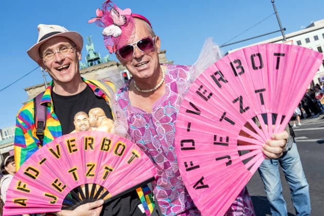 CSD Berlin 2026, Teilnehmer mit Fächern: AfD-Verbot jetzt, vor dem Brandenburger Tor, Auftakt am Freitag ab 17 Uhr, Drag* March Berlin, 24. Juli 2026 Deutschland, Berlin, 24. Juli 2026, CSD Berlin 2026, Teilnehmer mit Fächern: AfD-Verbot jetzt vor dem Brandenburger Tor, Auftakt Freitag ab 17 Uhr, Drag* March Berlin, CSD-Motto: Haltung ist hot, heute am Freitag lag die Temperatur bei 23 Grad, morgen am Samstag werden es 27 Grad, Christopher Street Day, 1. Tag des Berliner CSD-Wochenendes, Demonstration der queeren Community für gleiche Rechte und gesellschaftliche Akzeptanz, Community, Solidarität, Vielfalt, Demonstration, Freitagnachmittag ab 17 Uhr, feiern, *** CSD Berlin 2026, participants holding signs reading Ban the AfD Now in fr