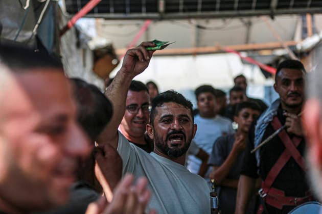 Gaza Families Celebrate Tawjihi Success A Palestinian man raises a banknote as residents gather during celebrations of the Tawjihi results in Gaza City, northern Gaza Strip, on July 23, 2026. Families in displacement camps and neighborhoods across northern Gaza City held modest celebrations for students who passed the Tawjihi examinations amid war, blockade and severe humanitarian conditions. Gaza Gaza Strip Palestinian Territories Copyright: xFaizxQreqax