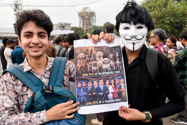 Kolkata Rally Supports CJP Protest Two demonstrators, one wearing a Guy Fawkes mask, hold a satirical political poster in Kolkata, India, on July 24, 2026. The rally was held in solidarity with the Cockroach Janta Party s ongoing protest at New Delhi s Jantar Mantar demanding the resignation of Education Minister Dharmendra Pradhan over alleged NEET examination irregularities, as leaders of the youth-led movement held a second round of talks with government officials after Prime Minister Narendra Modi pledged legal reforms and swift punishment for those involved in exam paper leaks. Kolkata West Bengal India Copyright: xDebajyotixChakrabortyx