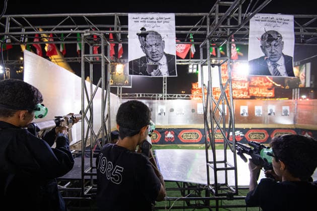 Demonstrators shoot at photos of US President Donald Trump and Israeli Prime Minister Benjamin Netanyahu with pellet guns during a pro‘government protest in Tehran, Iran on Friday, July 24, 2026. U.S. and Iran traded attacks for the 13th night in a row with few signs of either side returning to negociations.  IRN2026072413 BehnamxTofighi