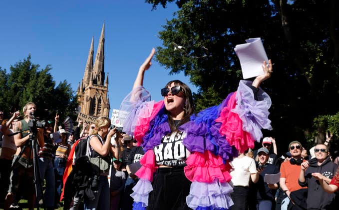 SING-IN PROTEST, Victoria Falconer theatre maker, music director and cabaret artist leads protestors in song during a Sing in protest to support the Divine Playhouse at Hyde Park in Sydney, Saturday, July 25, 2026. The Trans Theatre Group was evicted from its rental property in Kent Street after its landlord Revelop terminated the venue s lease claiming offensive trade - a legal term deriving from an 1842 NSW law implemented to regulate foul smells and industrial waste - and never once in 184 years has a court been asked to consider if it extends to moral offensiveness. ( NO ARCHIVING SYDNEY NEW SOUTH WALES AUSTRALIA  Copyright: xJESSICAxHROMASx 20260725167787269800