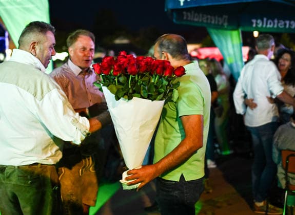 Freudenstadt 24.07.2026 Schwarzwald Air Open-Air-Festival auf dem Marktplatz: Ein Rosenverkaefer am Rande des Hauptact, DJ Oetzi *** Freudenstadt, July 24, 2026: Black Forest Air Open Air Festival on the Market Square. A rose vendor on the sidelines of the main act, DJ Oetzi