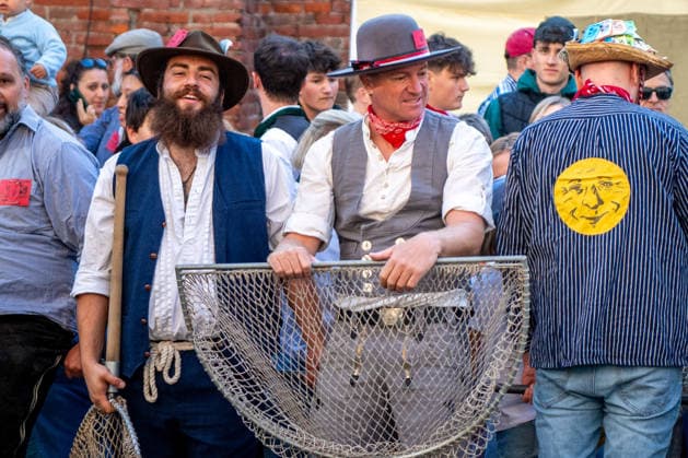 Ein Blick auf das traditionelle Bachausfischen während des Fischertags in Memmingen. Zahlreiche Fischer in teils historischer Kleidung waten durch den Stadtbach, um Fische zu fangen. Dicht gedrängt stehen Zuschauer am Ufer und verfolgen das Spektakel, das jährlich tausende Besucher anzieht. Im Hintergrund sind die historischen Mauern der Stadt zu sehen. Der Memminger Fischertag ist eines der ältesten und bekanntesten Volksfeste in Bayern. Memmingen Bayern Deutschland *** A look at the traditional stream fishing during Fishermen’s Day in Memmingen. Numerous fishermen, some in historical attire, wade through the town stream to catch fish. Spectators stand crowded together on the bank, watching the spectacle, which attracts thousands of