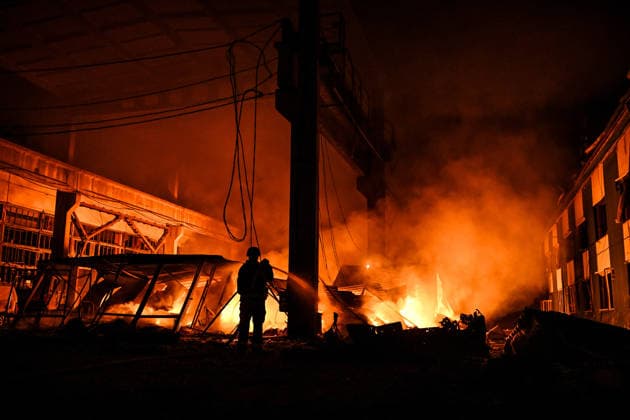 A rescuer extinguishes a fire at a shopping complex caused by a Russian attack in Zaporizhzhia, Ukraine, July 25, 2026. In the early hours of Saturday, July 25, Russian troops struck the southeastern Ukrainian city with drones, igniting a fire that spread through shops and trading pavilions over an area of about 900 square metres. A 63-year-old man was injured in the drone strike. (Photo by Dmytro Smolienko Ukrinform) Russian army attacks Zaporizhzhia with drones  Copyright: xDmytroxSmolienkox